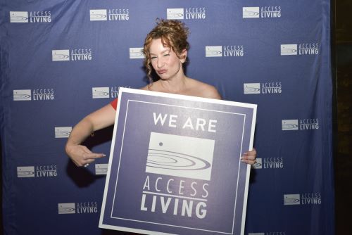 Katy Sullivan holding Access Living sign